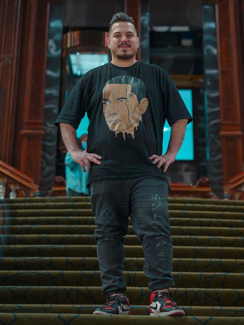 A Man in a Graphic Shirt Standing on a Stairway