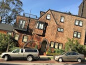 在阳光明媚的日子里，旧金山独特的砖砌建筑旁停放着车辆