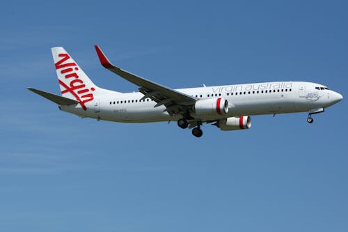 Free White and Red Virgin Australia Airplane Mid Air Under Blue and White Sky during Daytime Stock Photo