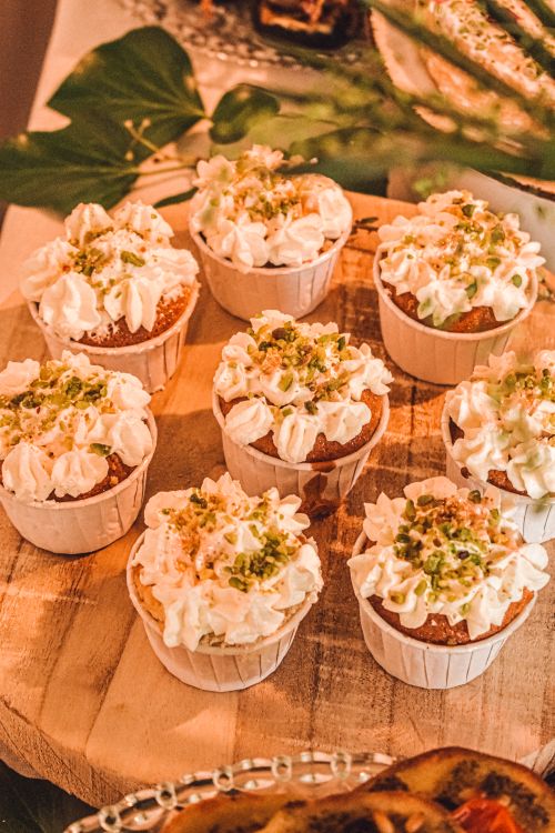 Free Eight tasty cupcakes topped with whipped cream and sprinkles on a wooden platter. Stock Photo