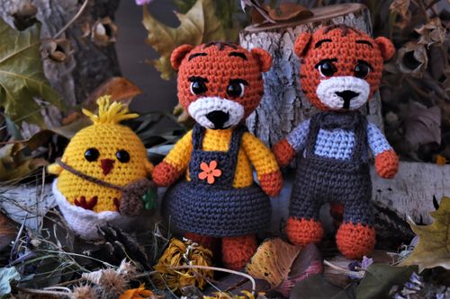 Free Charming handmade crochet toys pose amidst fallen leaves and tree logs in a cozy autumn scene. Stock Photo