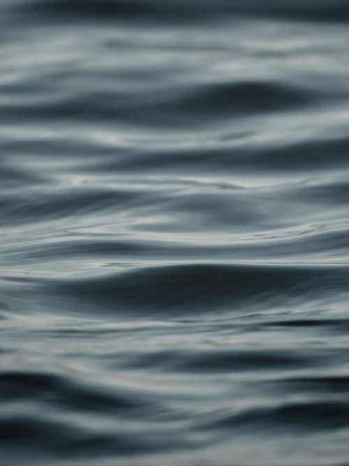 Free A serene close-up of calm blue water with gentle ripples, perfect for nature backgrounds. Stock Photo