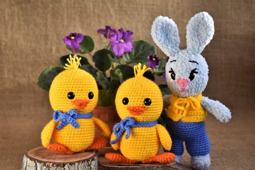 Free Charming crochet ducklings and bunny with vibrant purple flowers on burlap. Stock Photo