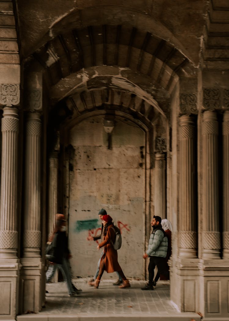 People Walking Through Arch 