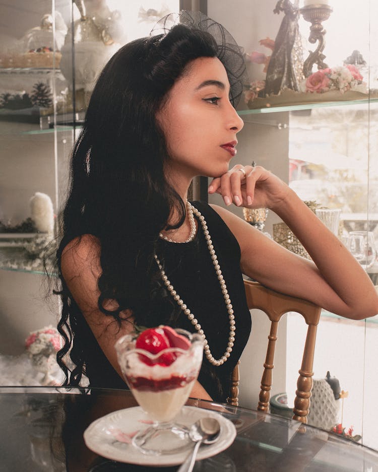 Beautiful Young Woman Sitting In A Cafe With A Dessert 