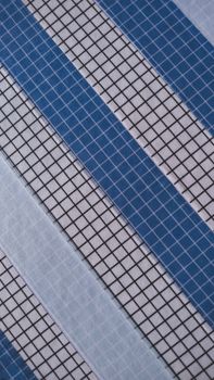 Diagonal grid pattern with alternating blue and white stripes creating a geometric abstract design.