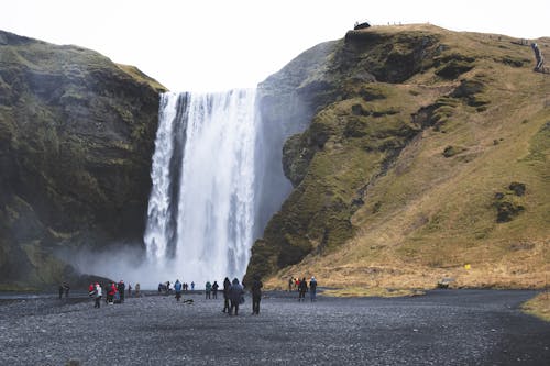 People Standing Near Waterfall