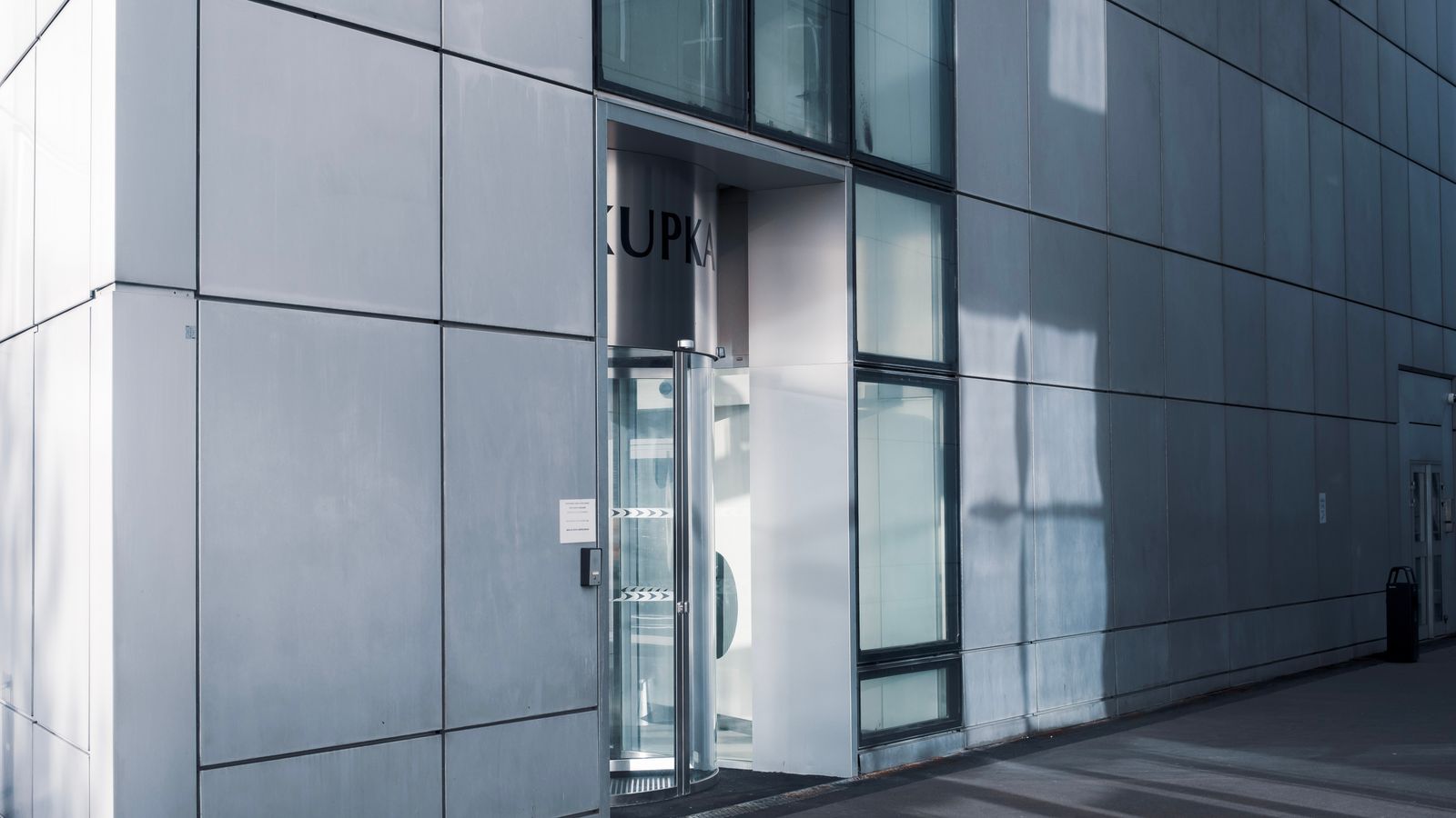 Sleek modern architecture with a glass entrance and reflective facade — photo by Mathias Reding on Pexels