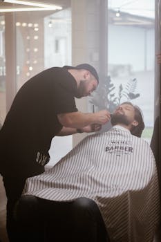 Barber giving a client a close shave in a contemporary salon setting.
