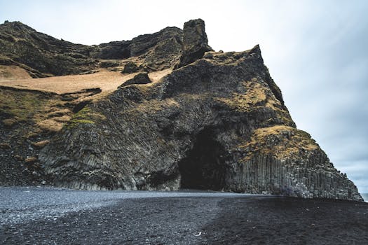 Majestic basalt cave and black sand beach in Iceland showcasing dramatic geological formations.