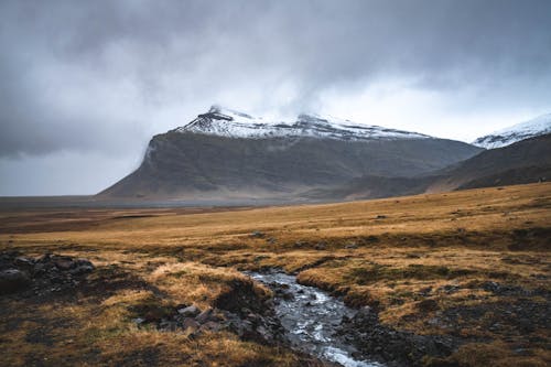 Landscape Scenery of an Open Field Across the Mountain