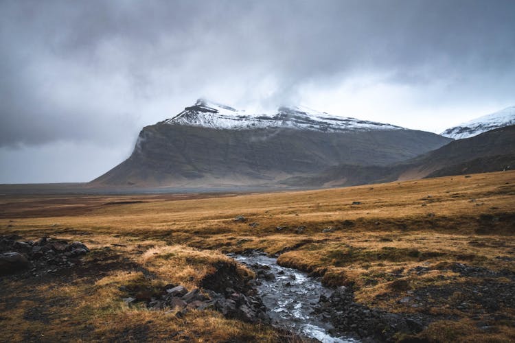 Landscape Scenery Of An Open Field Across The Mountain