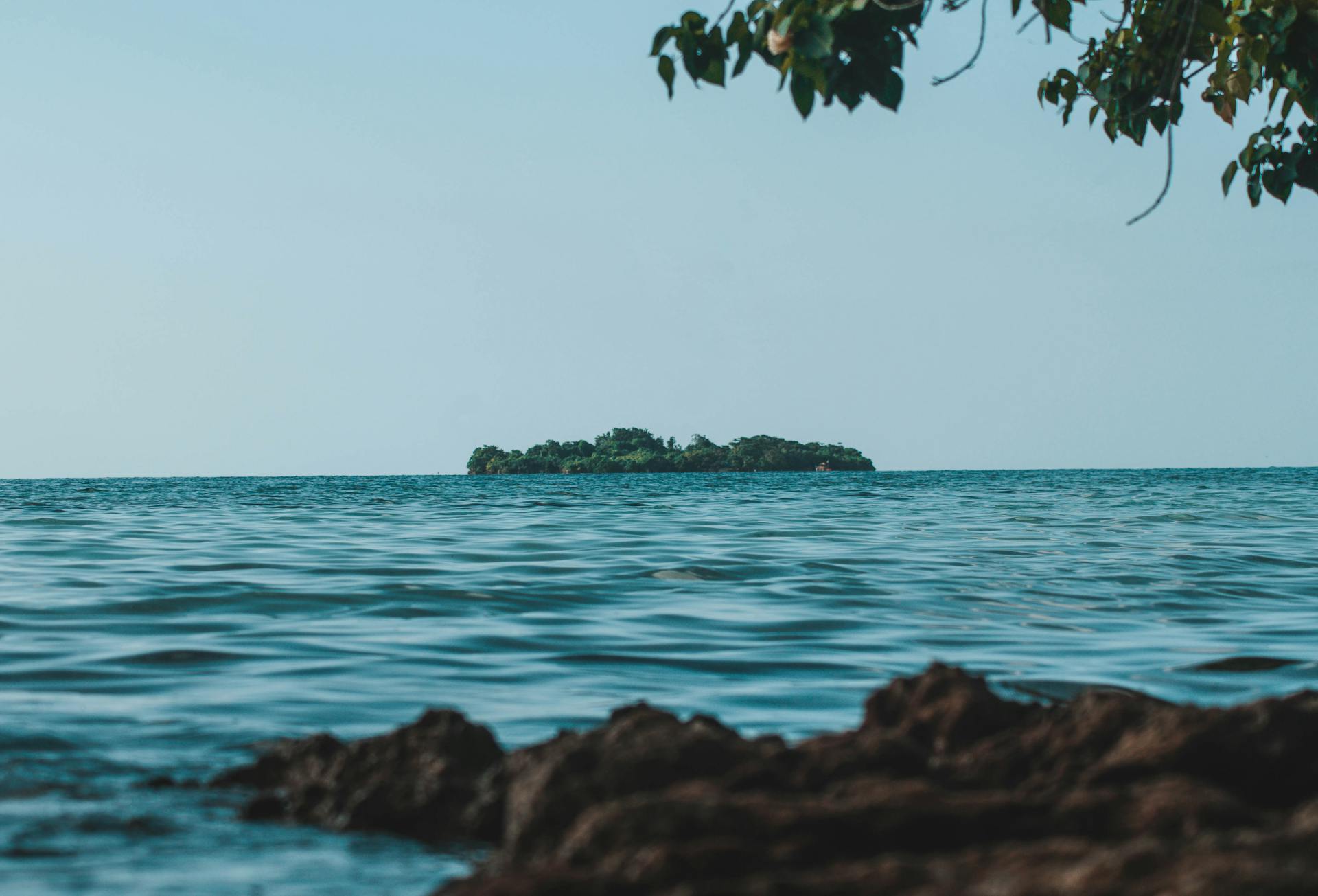 Peaceful island view from the coast of Negril, Jamaica under clear blue skies.