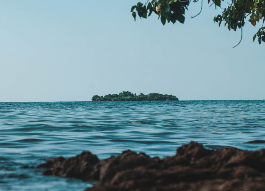 Peaceful island view from the coast of Negril, Jamaica under clear blue skies.