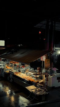 An atmospheric view of a vibrant Turkish market stall lit up at night, offering street food.