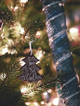 Close-up of a festive 'Joy to the World' ornament on a Christmas tree.