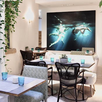 Stylish restaurant interior featuring modern furniture and a striking underwater painting.