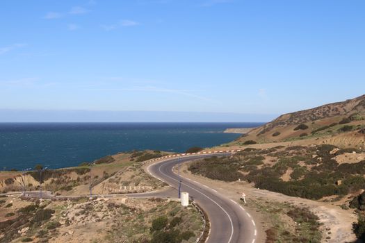 Explore the winding coastal road with ocean views in Mostaganem, Algeria.