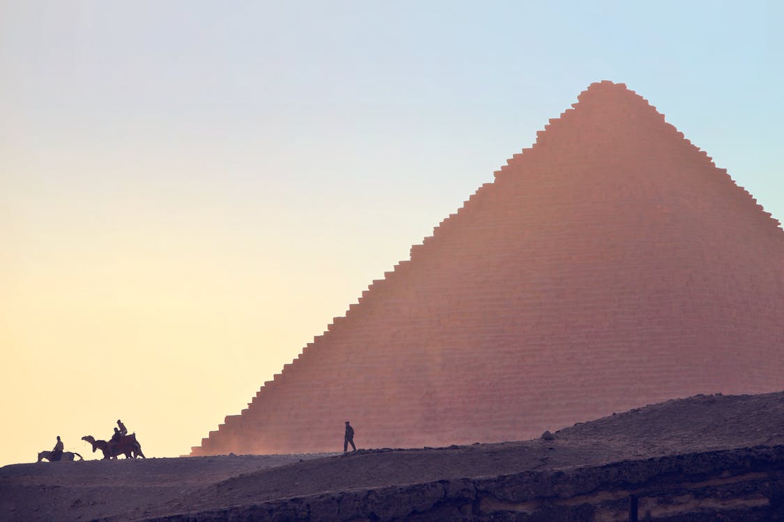 People Near a Pyramid Under a Blue Sky