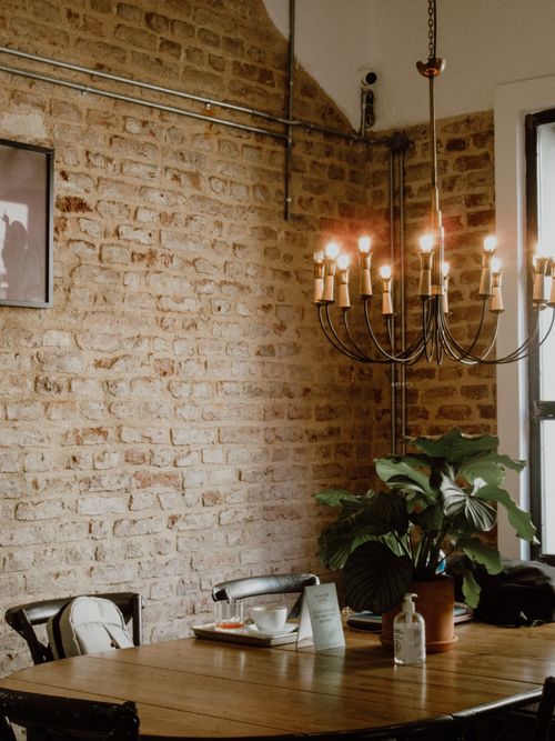 Free Warm brick interior in Istanbul with a vintage chandelier and a lush plant. Stock Photo