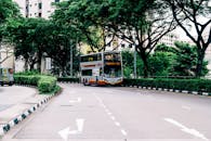 巴士在新加坡安静的街道上行驶，周围环绕着绿植和高楼