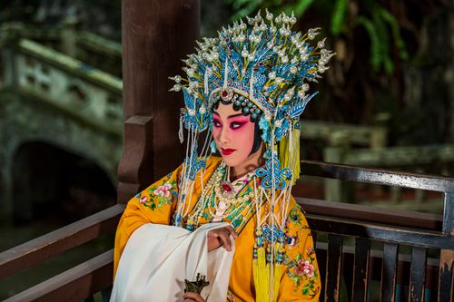 Free Close-up of a Chinese opera performer in colorful traditional attire and intricate makeup, set outdoors. Stock Photo