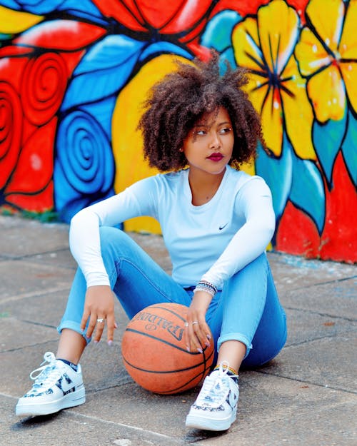 Woman Sitting on Pavement with Basketball