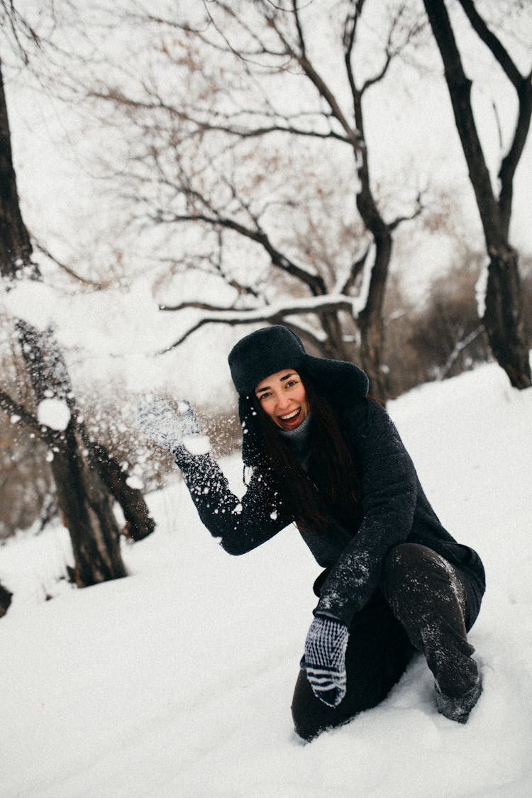 Smiling Woman Throwing A Snowball 