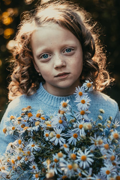 Girl with Curly Hair Holding Bunch of Daisies