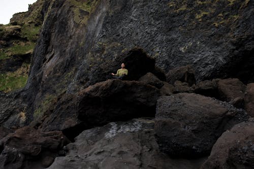 Фотография человека, медитирующего на вершине скалы