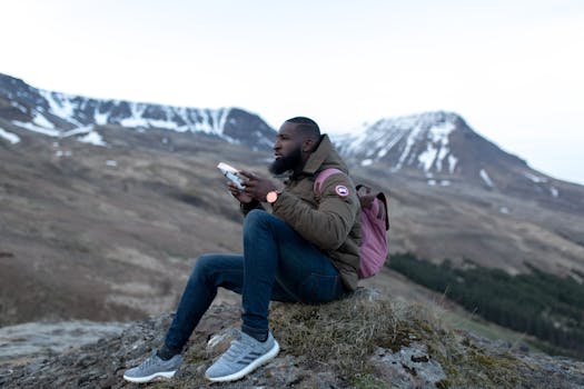Backpacker pauses during a scenic mountain hike with snowy peaks in the background.