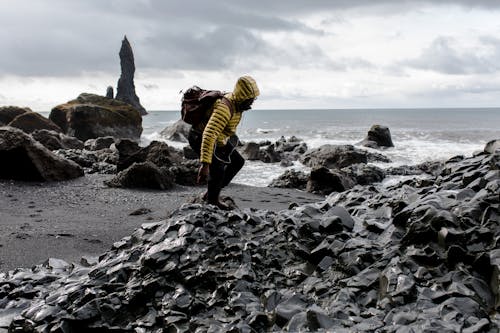 Free Photo of Man in Yellow Hoodie Near Seashore Stock Photo