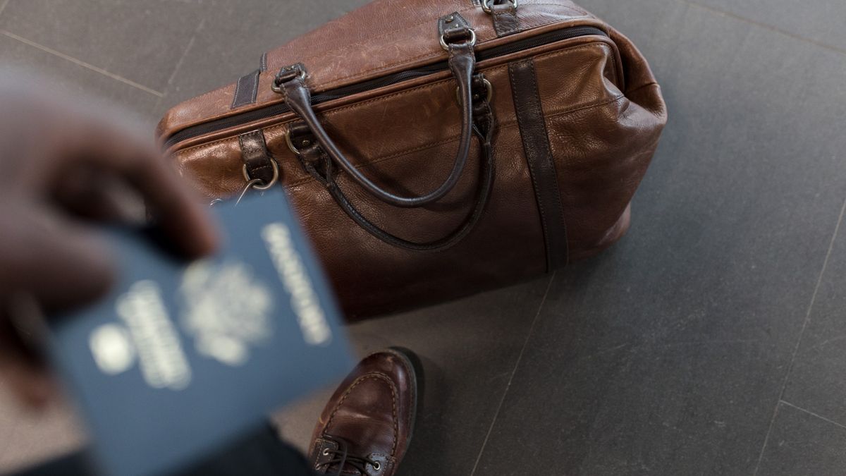 A passport and travel bag on an airport counter representing Europe entry requirements in 2026