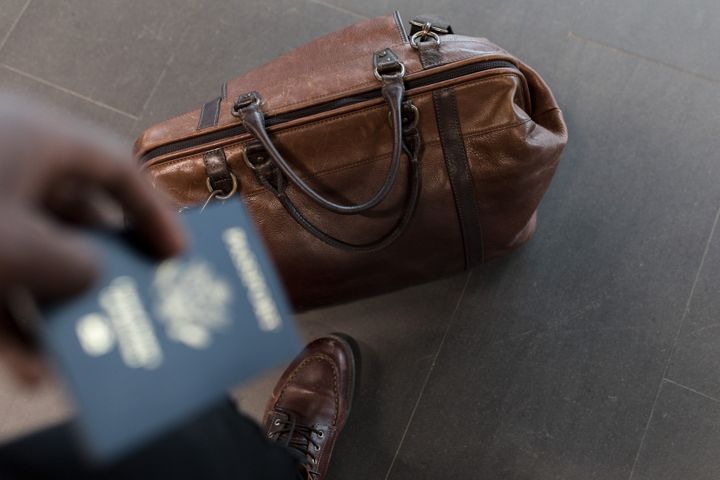 Resväska och pass på flygplatsen inför en resa