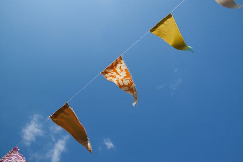 무료 낮 동안 파란색 흰색 하늘 아래 주황색 노란색과 빨간색 깃발 스톡 사진