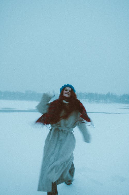 A Woman in Winter Clothes Throwing Snowball