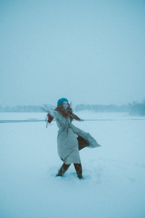 

A Woman Dancing on a Snow Covered Field