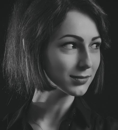 Grayscale Photo of Woman Wearing Collared Shirt Looking Sideways