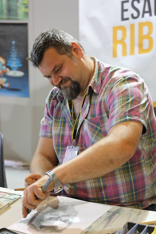 Man Wearing Pink Checkered Shirt While Sketching