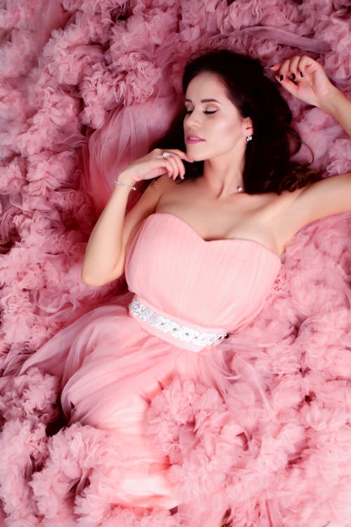 ピンクの恋人のネックラインのドレスを着て横たわっている女性