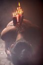 Lit Red and White Candle Lot on Person's Back