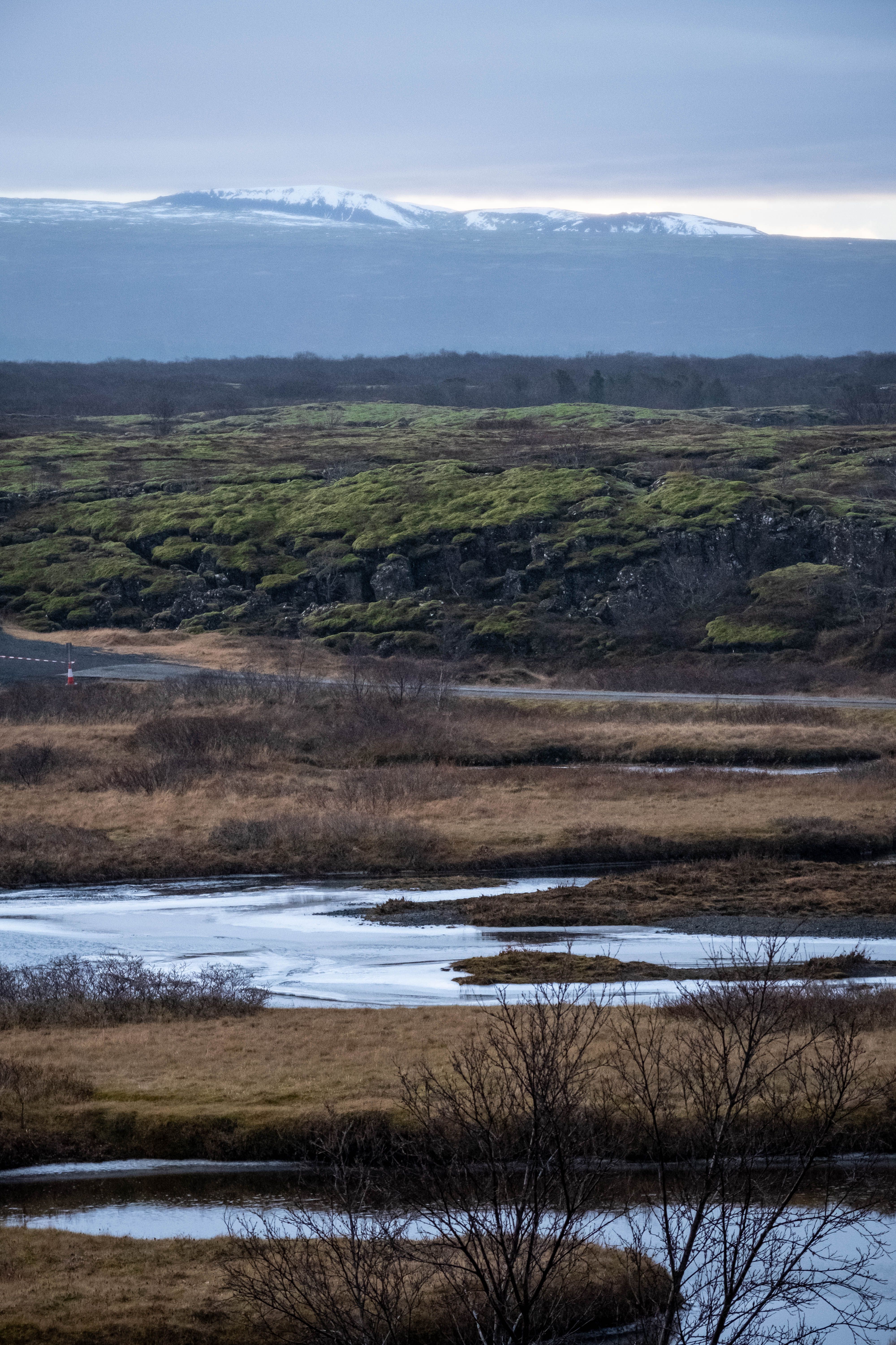 Rugged Iceland landscape of snow-capped mountains, glacial rivers, and open volcanic plains.
