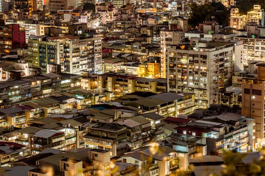 Stunning aerial view of a bustling urban cityscape at night, showcasing illuminated buildings and vibrant architecture.