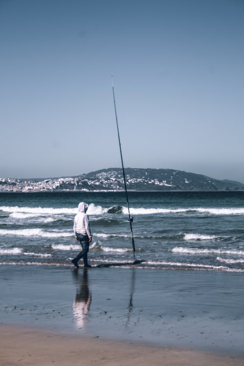 A Fisherman Surf Casting at the Beach