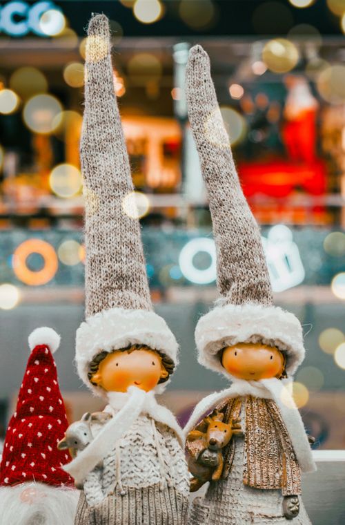 Free Two cute Christmas dolls in festive attire with bokeh lights in the background. Stock Photo