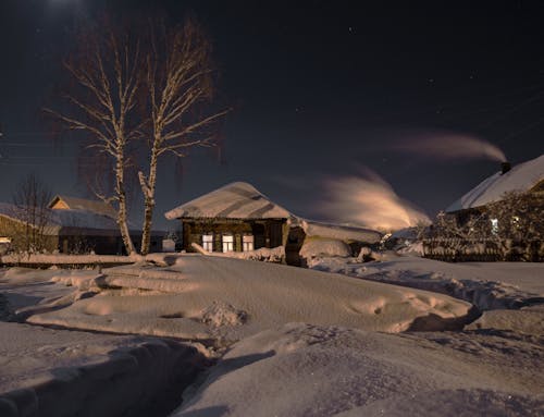 Houses and Yard Covered in Snow at Night 