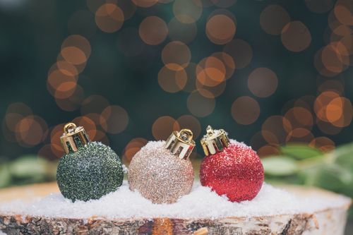 Free Festive Christmas baubles on snow with a soft bokeh background capturing a cozy holiday mood. Stock Photo
