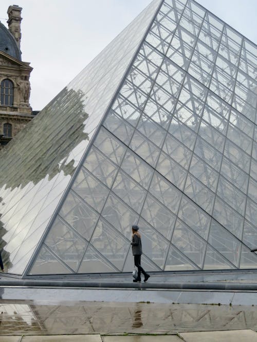 

A Woman Walking beside the Louvre Museum