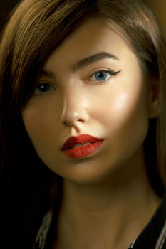 Close-up portrait showcasing a woman's striking red lips and blue eyes with elegant makeup.