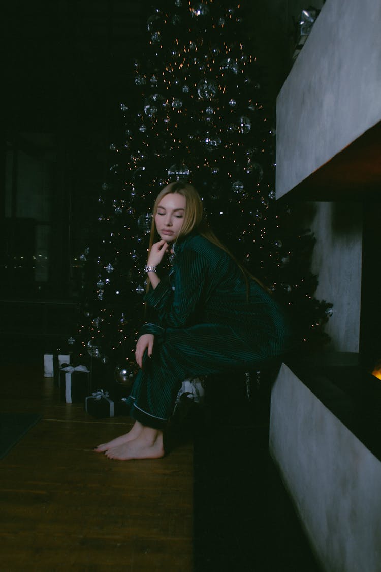 Woman In Green Pajama Sitting Near A Christmas Tree